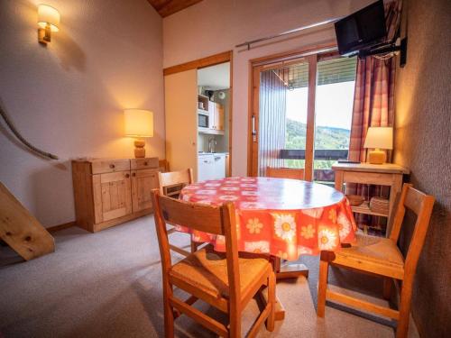 une salle à manger avec une table et des chaises et une fenêtre dans l'établissement Résidence Orgentil G - ORGENTIL 24 MAE-6611, à Valmorel