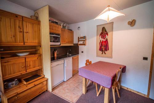 une petite cuisine avec une table et un chiffon rouge dans l'établissement Résidence Mucillon G - MUCILLON 29 MAE-6701, à Valmorel