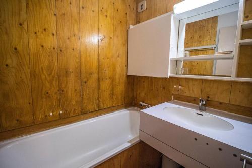 une salle de bain avec un lavabo et une baignoire dans l'établissement Résidence Mucillon G - MUCILLON 29 MAE-6701, à Valmorel