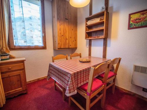 - une table à manger avec des chaises et un tissu de table en damier dans l'établissement Résidence Bourgeon G - BOURGEON 03 MAE-6741, à Valmorel