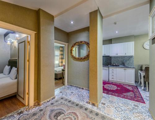 a room with a bed and a kitchen with a mirror at Lemis Suite Istanbul in Istanbul
