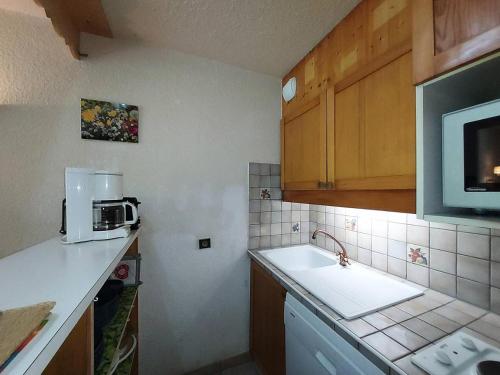 une petite cuisine avec un évier et un micro-ondes dans l'établissement Résidence Cheval Noir G - CHEVAL NOIR 23 MAE-6791, à Valmorel