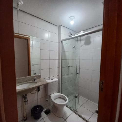 a bathroom with a toilet and a glass shower at Apartamento Taguatinga Sul 2 quartos com garagem elevador 1 a 4 hospedes sem taxas in Brasilia