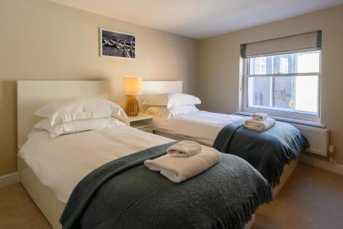 a bedroom with two beds with towels on them at The Pickled Herring in Beccles