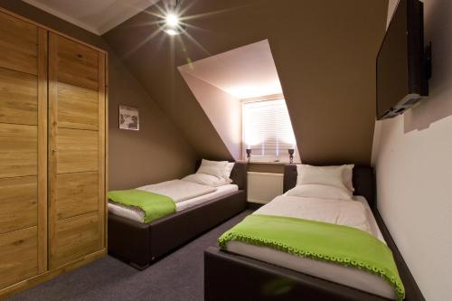 a small room with two beds and a window at Café Pension Steffen in Sanitz