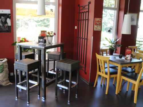 a dining room with two tables and yellow chairs at Café Pension Steffen in Sanitz
