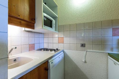 une cuisine avec un évier et un micro-ondes dans l'établissement Résidence Pierrer G - PIERRER 6 MAE-6861, à Valmorel