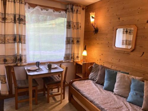 une chambre avec un lit, une table et une fenêtre dans l'établissement Résidence Riondet G - RIONDET 27 MAE-6891, à Valmorel