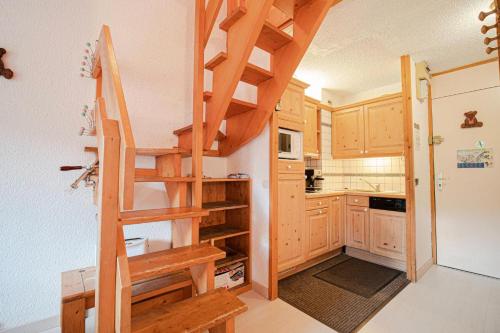 - une cuisine avec des escaliers en bois dans une petite maison dans l'établissement Résidence Pierres Plates G - PIERRES PLATES 54 MAE-6911, à Valmorel