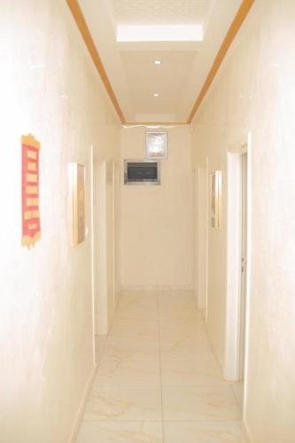 a hallway of a building with white walls and a ceiling at Charly business in Mpita
