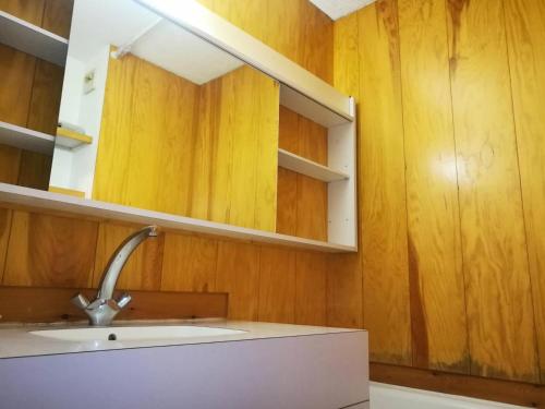 - une cuisine avec des murs en bois, un lavabo et un miroir dans l'établissement Résidence Pierrafort G - PIERRAFORT 41 MAE-6921, à Valmorel