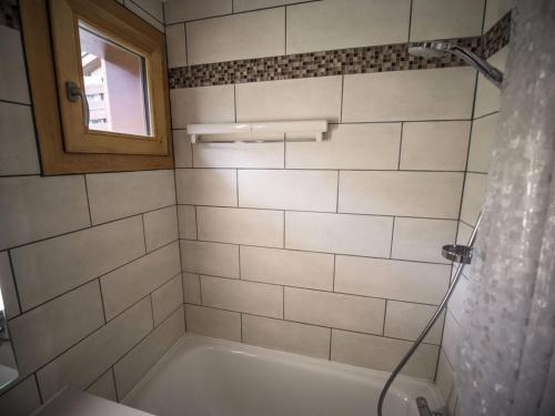 une salle de bain avec une baignoire et une fenêtre dans l'établissement Résidence Lauziere Dessus G - LAUZIERE DESSUS 21 MAE-6961, à Valmorel