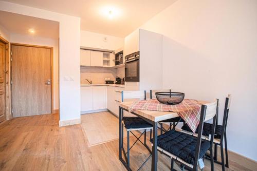 une cuisine et une salle à manger avec une table et des chaises dans l'établissement Résidence Lumi Batiment B - LUMI B 302 MAE-7011, à Valmorel