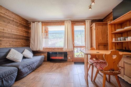 un salon avec un canapé et une cheminée dans l'établissement Résidence Ruelle G - RUELLE 6 MAE-7021, à Valmorel