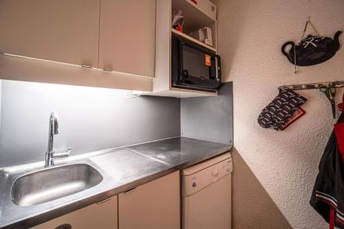 une petite cuisine avec un évier et un micro-ondes dans l'établissement Résidence Portail G - PORTAIL 42 MAE-7031, à Valmorel