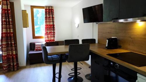 une cuisine avec une table et des chaises dans une pièce dans l'établissement Résidence Lauziere Dessous G - LAUZIERE DESSOUS 48 MAE-7071, à Valmorel