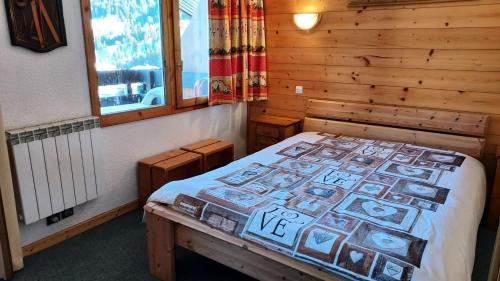 une chambre avec un lit dans une cabane en bois dans l'établissement Résidence Caillou G - CAILLOU 16 MAE-7051, à Valmorel