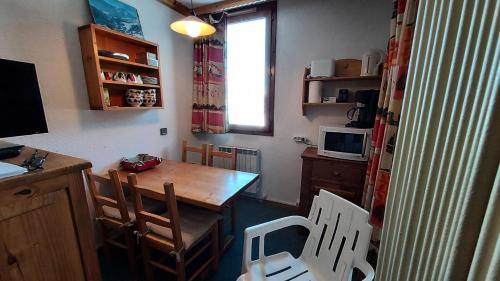 une cuisine avec une table et des chaises dans une pièce dans l'établissement Résidence Caillou G - CAILLOU 16 MAE-7051, à Valmorel
