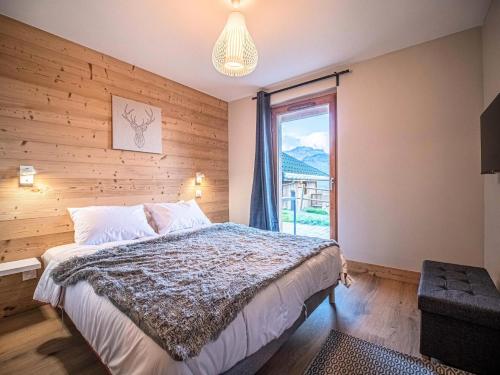 une chambre avec un grand lit et une fenêtre dans l'établissement Chalet Meije - CHALET MEIJE MAE-7151, à Valmorel