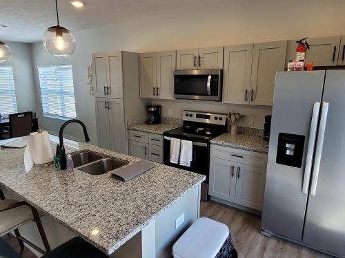 a kitchen with a refrigerator and a counter top at The HoneyBee at Coventry Rows in Omaha