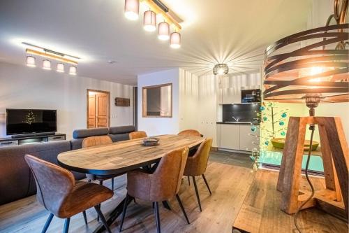 un salon avec une table et des chaises en bois dans l'établissement Résidence Lumi Batiment B - LUMI B 504 MAE-7161, à Valmorel