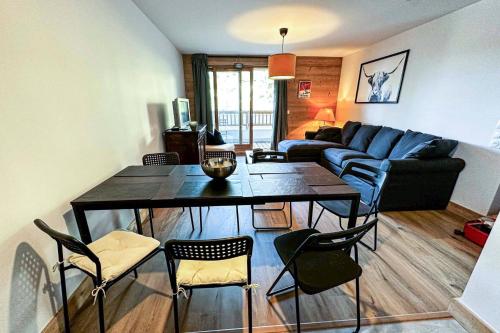 un salon avec une table, des chaises et un canapé dans l'établissement Résidence Lumi Batiment B - LUMI B 402a MAE-7191, à Valmorel