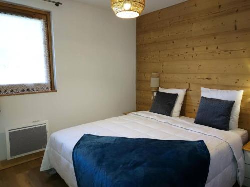 une chambre avec un grand lit avec un mur en bois dans l'établissement Résidence Lumi Batiment B - LUMI B 104 MAE-7211, à Valmorel