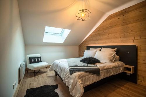 une chambre avec un grand lit avec une lucarne dans l'établissement Résidence Lumi Batiment B - LUMI B ALPAGA 306 MAE-7221, à Valmorel