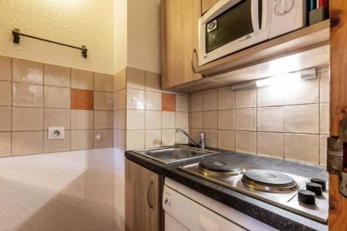 une cuisine avec un évier et un micro-ondes dans l'établissement Résidence Lauziere Dessous G - La Lauziere Dessous 20 MAE-7301, à Valmorel