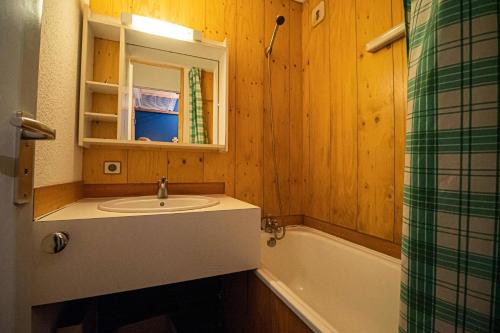 une salle de bain avec un lavabo et une baignoire dans l'établissement Résidence Cheval Blanc G - CHEVAL BLANC C73 MAE-9261, à Valmorel