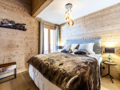 - une chambre avec un grand lit dans un mur en bois dans l'établissement Les Chalets Du Gypse - LES CHALETS DU GYPSE A05 MAE-3471, à Saint-Martin-de-Belleville