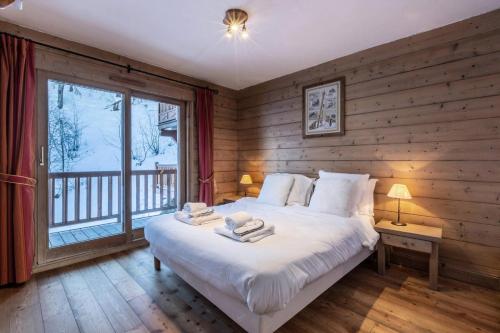 une chambre avec un grand lit et une grande fenêtre dans l'établissement Les Chalets Du Gypse - LES CHALETS DU GYPSE C02 MAE-3601, à Saint-Martin-de-Belleville