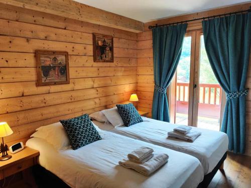 deux lits dans une chambre aux murs en bois dans l'établissement Les Chalets Du Gypse - LES CHALETS DU GYPSE C10 MAE-3651, à Saint-Martin-de-Belleville