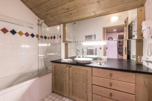 La salle de bains est pourvue de 2 lavabos, d'une douche et d'une baignoire. dans l'établissement Les Chalets Du Gypse - LES CHALETS DU GYPSE C15 MAE-3691, à Saint-Martin-de-Belleville