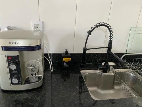 a kitchen counter with a coffee maker and a sink at Apartamento 102 até 9 pessoas com garagem in Ipatinga