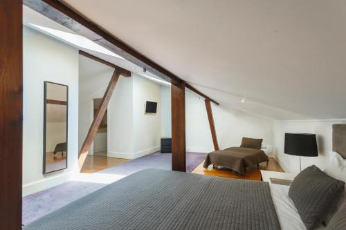 a bedroom with a bed and a couch in a room at Madalena EXCLUSIVE SUITES in Lisbon