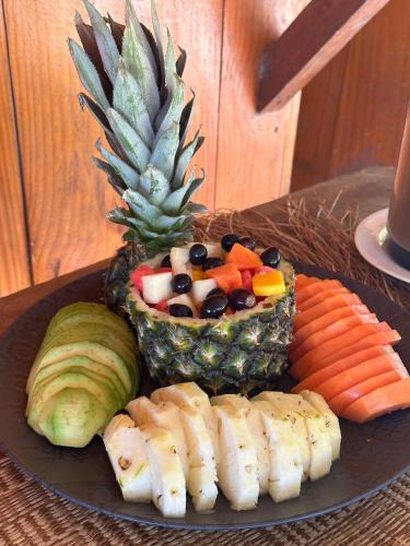 a plate with a pineapple and vegetables on a table at Casa da Duna in Tatajuba