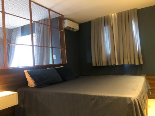 a bedroom with a bed and a window at Flat Red Sorocaba - Gray in Sorocaba