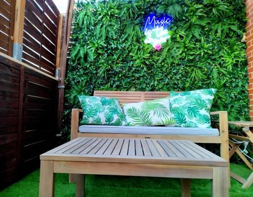 a bench sitting in front of a green wall at Terraza acogedora , Piscina , Parking, Aire Acondicionado, in El Campello