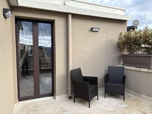 two chairs sitting on a patio with a house at SVR Palace in Bronte