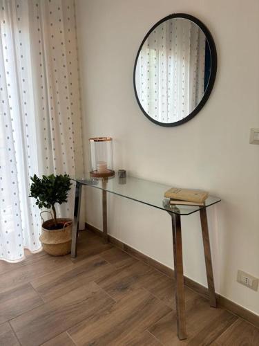 a glass table in a room with a mirror at SVR Palace in Bronte