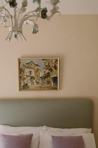 a chandelier above a bed with a painting above it at El Cid Country Club in Benidoleig
