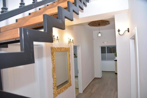 a mirror on the wall in a hallway with a staircase at Vila Franko in Berat