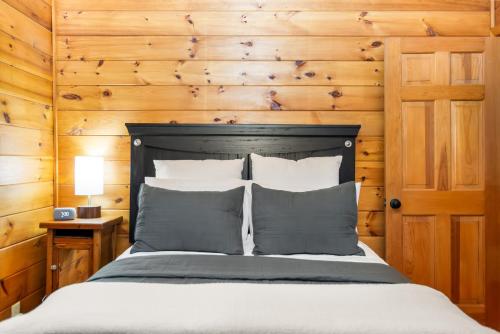 a bedroom with a bed with a wooden wall at Downward Dog Lodge - Hot Tub, Pool Table, Fireplace, Yoga Den in Blue Ridge