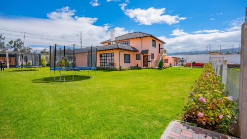 a yard with a house and a playground at Casa amplia cerca de Baños de Agua Santa in Picaigua