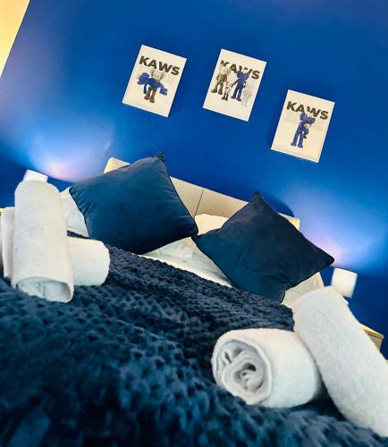 a bed with towels on it with a blue wall at Gifford St Retreat 3BR Entire Home in Middlesbrough