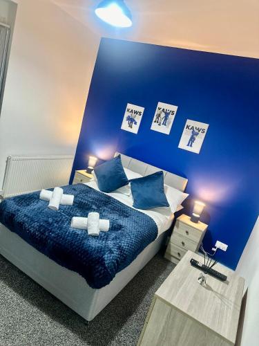 a bedroom with a blue wall with a bed at Gifford St Retreat 3BR Entire Home in Middlesbrough