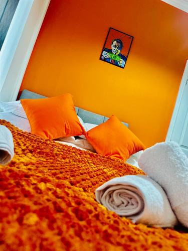 a bedroom with a bed with an orange wall at Gifford St Retreat 3BR Entire Home in Middlesbrough