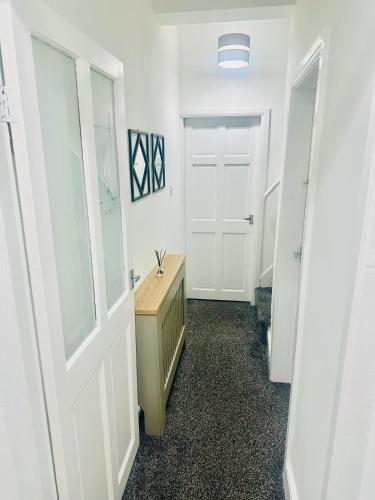 a hallway with a white door and a sink at Gifford St Retreat 3BR Entire Home in Middlesbrough