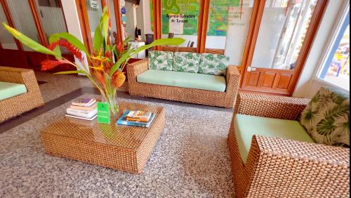 a room with wicker chairs and a table with a vase at Hotel Anaconda in Leticia
